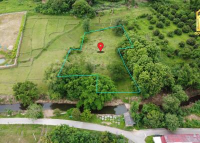 Aerial view of a plot of land marked within a larger green landscape with trees and fields