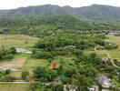 Aerial view of property and surrounding green landscape with mountains