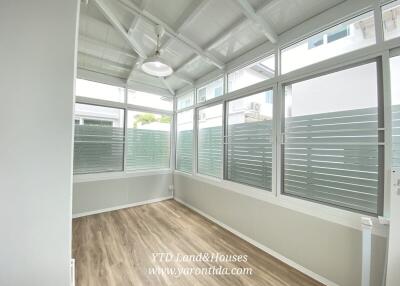 Bright sunroom with large windows and wood flooring