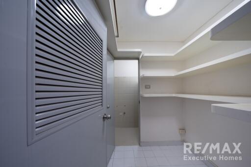 Photo of a utility room with shelves and grey door