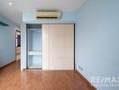 Modern empty bedroom with blue walls and built-in wardrobe