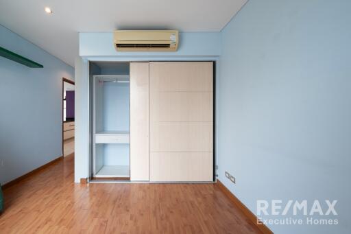 Modern empty bedroom with blue walls and built-in wardrobe