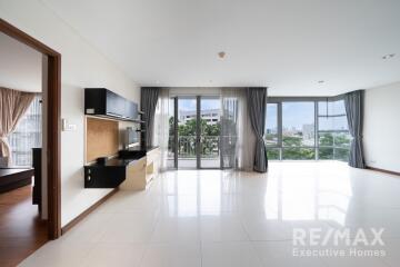 Spacious living room with large windows and balcony overlooking greenery