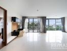 Spacious living room with large windows and balcony overlooking greenery