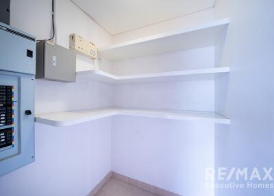 Utility room with electrical panels and shelves