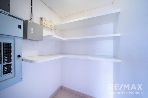 Utility room with electrical panels and shelves