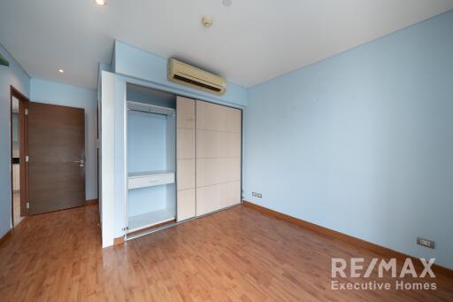 Spacious bedroom with wooden flooring and inbuilt wardrobe