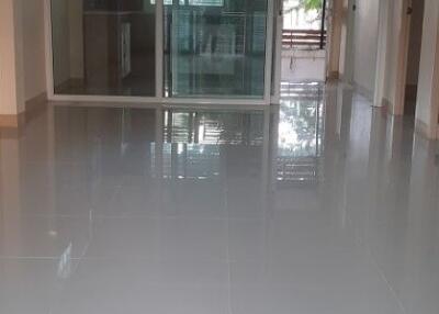 Hallway with polished floors leading to a balcony