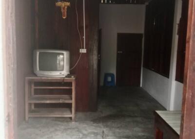 A rustic living room with wooden walls and a vintage television.