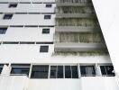 Exterior view of a multistory building with balconies and plants