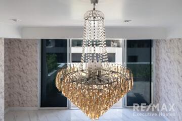 Spacious living room with large windows and a chandelier