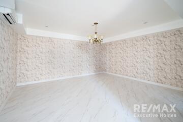 spacious empty living room with chandelier and marble floor