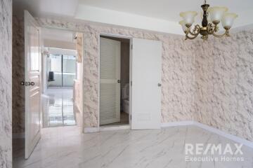 Main living space with chandelier and marble wall