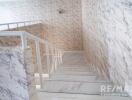 Interior staircase with marble textured walls and steps