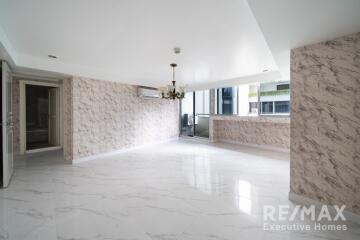 spacious living room with marble floors and large windows