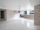 spacious living room with marble floors and large windows