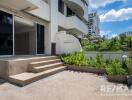 Outdoor patio area with stairs leading to a sliding glass door entry.