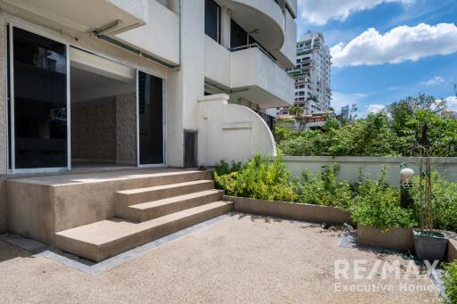 Outdoor patio area with stairs leading to a sliding glass door entry.