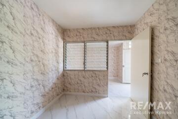 Empty bedroom with marble-patterned wallpaper