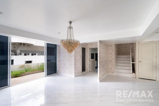 Spacious living area with chandelier and marble flooring