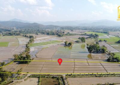 Aerial view of farmland with surrounding hills, marked with a property boundary.