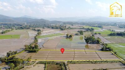 Aerial view of farmland with surrounding hills, marked with a property boundary.