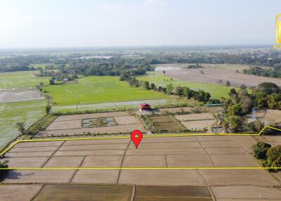 Aerial view of expansive farmland with surrounding greenery