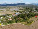 Aerial view of village by fields and mountains