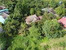 Aerial view of a property plot with surrounding greenery and nearby houses