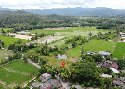 Aerial view of a plot of land with surrounding greenery and buildings