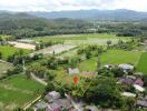 Aerial view of a plot of land with surrounding greenery and buildings