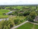 Aerial view of a plot of land with surrounding greenery and houses