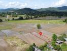 Aerial view of agricultural land with surrounding mountainous landscape.