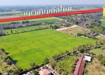 Aerial view of a large green field with a surrounding area in countryside