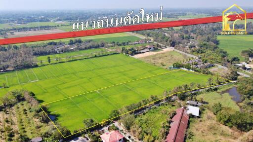 Aerial view of a large green field with a surrounding area in countryside