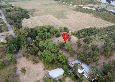 Aerial view of a large property lot surrounded by trees and adjacent to open fields