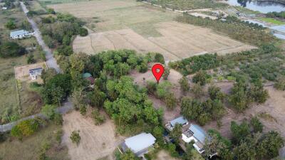 Aerial view of a large property lot surrounded by trees and adjacent to open fields