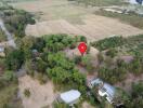 Aerial view of a large property lot surrounded by trees and adjacent to open fields