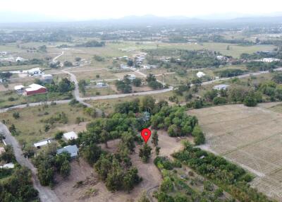 Aerial view of a rural landscape with roads, buildings, and greenery.