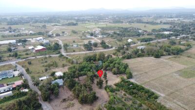 Aerial view of a rural landscape with roads, buildings, and greenery.