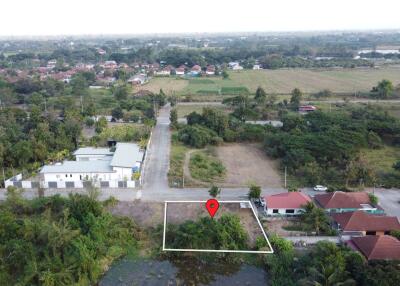 Aerial view of a land plot with a marked location in a semi-urban area