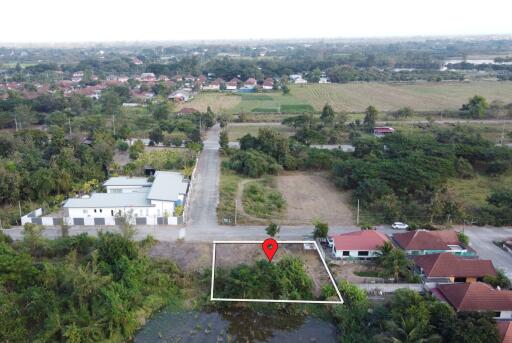 Aerial view of a land plot with a marked location in a semi-urban area