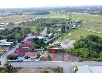 Aerial view of a residential neighborhood with a highlighted land plot