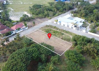 Aerial view of a plotted land area with surrounding greenery