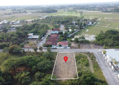 Aerial view of a land lot with surrounding houses and fields