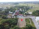 Aerial view of a land lot with surrounding houses and fields