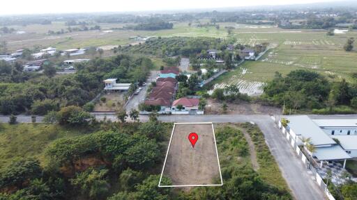 Aerial view of a land lot with surrounding houses and fields