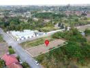 Aerial view of an available building plot marked with a red pin