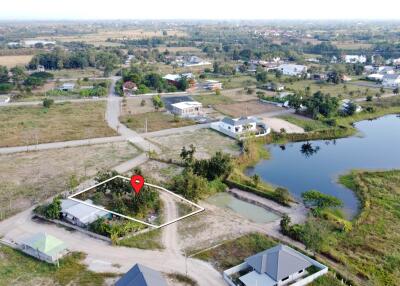 Aerial view of a neighborhood with roads, houses, and a nearby body of water