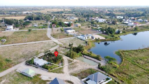 Aerial view of a neighborhood with roads, houses, and a nearby body of water